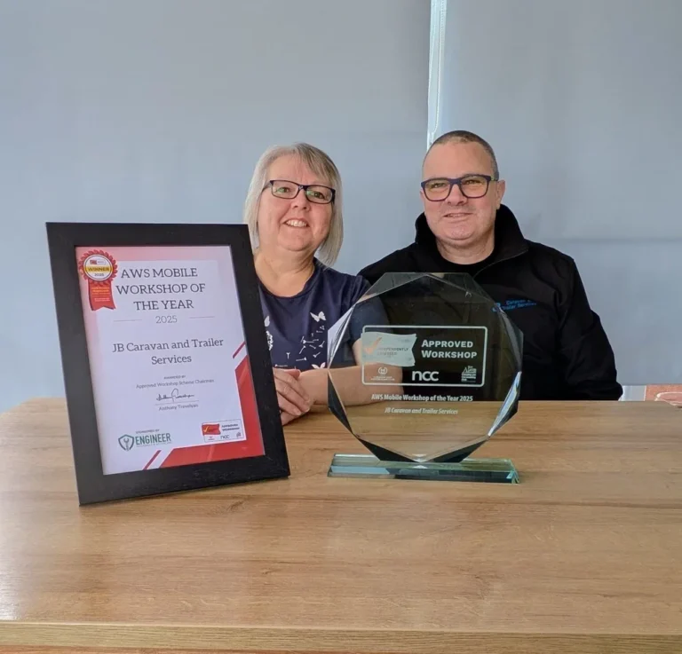 Jamie and Jane Bell from JB Caravan and Trailer Services posing with their certificate and glass trophy for AWS Mobile Workshop of the Year 2025